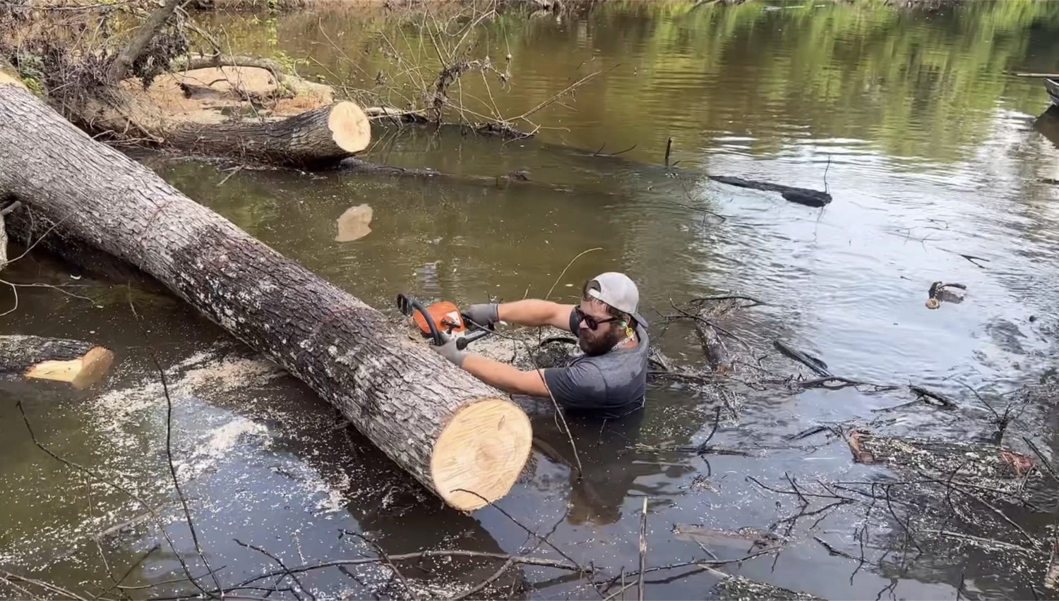 Crew cutting and clearing a river obstruction