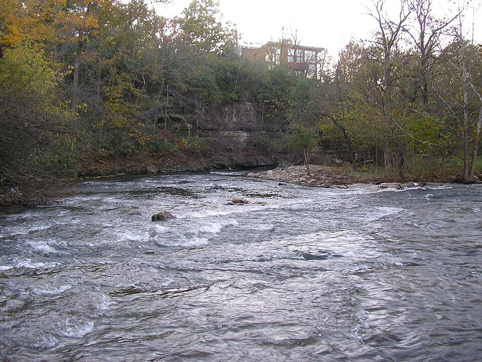 Beargrass Creek flowing across a rocky streambed beside wooded banks.